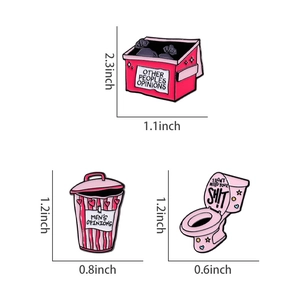 Vue détaillée de trois épingles en émail rose au design créatif de toilette et poubelle