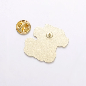 Close-up of golden alloy pin back with butterfly clutch and textured metal surface