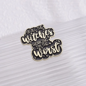 Macro detail of enamel brooch with witty text design and elegant gold metallic edging