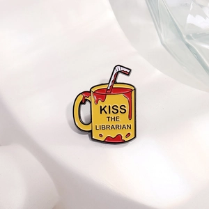 Creative enamel metal pin featuring a yellow librarian mug with red liquid filling