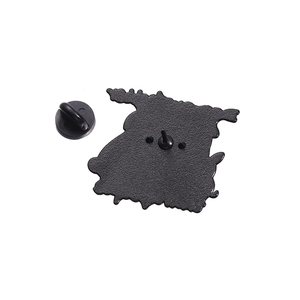 Detailed macro view showing the textured black metal back and rubber clutch of the dog badge