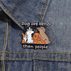 Cartoon dog enamel pin featuring the slogan Dogs are better than people on denim jacket