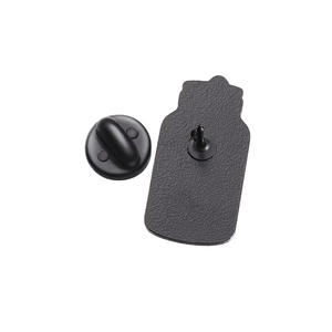 Detail of cartoon badge back with textured black metal base and rubber clutch pin closure