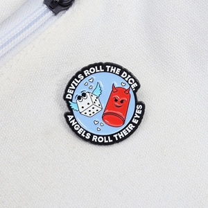 Cartoon enamel pin featuring a red devil and white winged dice with motivational text quote