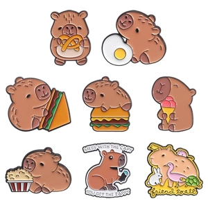 Detail of colorful enamel capybara badges featuring cute animal and food designs