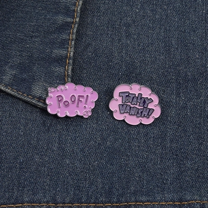 Détail de pin's en émail rose avec texte POOF sur fond en tissu denim bleu