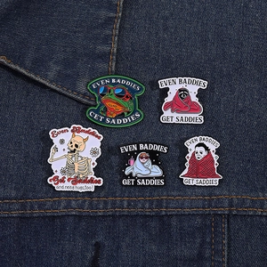 Detailed view of five enamel pins with humor quotes on dark denim jacket fabric