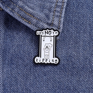 Detail of enamel pin with humorous fitness design on blue denim fabric background