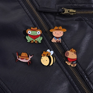 Set of five cowboy-themed enamel animal pins displayed on a black leather jacket collar