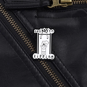 Macro detail of enamel pin with pull-up workout design on a black leather jacket
