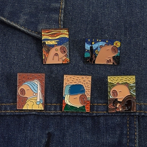 Detail of five Capybara enamel pins styled as famous classic oil paintings on denim fabric