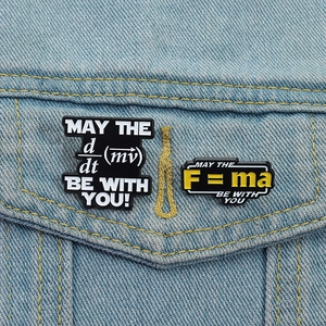 Detailed view of physics formula enamel pins featuring F=ma on a denim jacket pocket