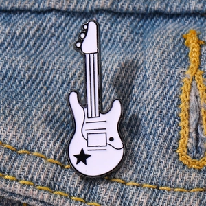 Detail of creative electric guitar enamel pin with black star on blue denim jacket
