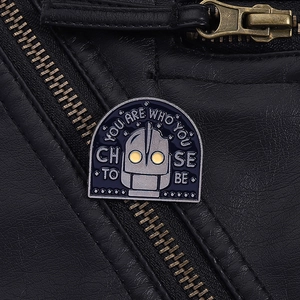 Close-up of The Iron Giant enamel pin featuring yellow eyes on a leather jacket
