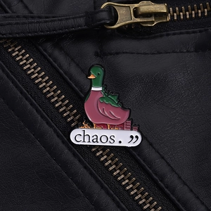 Detail of chaos duck enamel pin on black leather jacket with burning city design