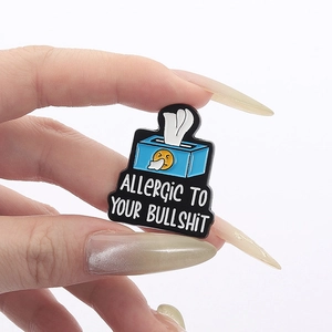 Détail du pin's émaillé boîte à mouchoirs bleue avec texte Allergic to Your Bullshit