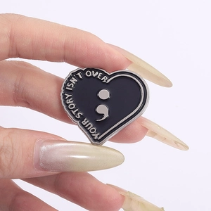 Gros plan d'une épingle coeur avec point-virgule et texte Your Story Isn't Over