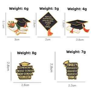 Detail view of 2025 graduation enamel pins showing doctoral cap and scroll designs