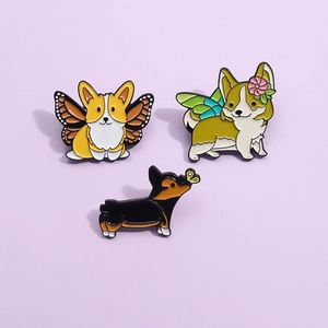 Détails de trois pins émaillés de chiens Corgi mignons avec des ailes de papillon