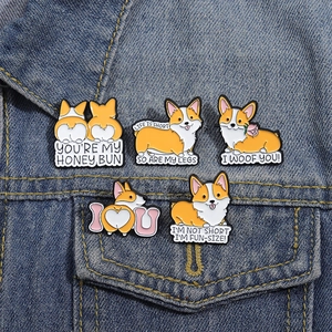 Detalle de cinco pines de esmalte de Corgi prendidos en el bolsillo de una chaqueta