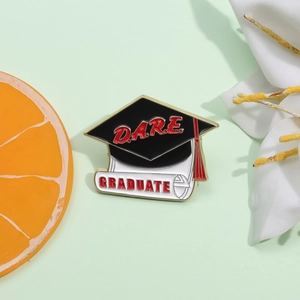 Black 2025 graduation cap and scroll enamel pin set with red DARE and GRADUATE text