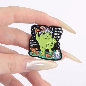 Detailed enamel pin showing wizard frog with purple hat, orange mushroom, and star magic