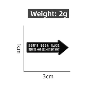 Detailed view of black arrow enamel pin with Don't Look Back quote measuring 3cm x 1cm