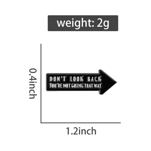 Detailed view of black arrow enamel pin with white Don't Look Back quote and size info