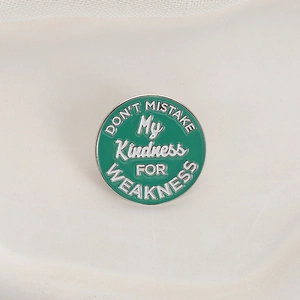 Minimalist round enamel brooch featuring Don't Mistake My Kindness for Weakness quote