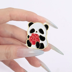 Detailed close-up of a cute panda enamel pin holding a red flower with gold metal edges