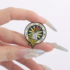 Detail of candle enamel pin with 'Rage against the dying of the light' quote