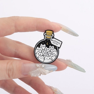 Detail of Happiness Potion cat pin with white enamel kitty in a bottle on hand