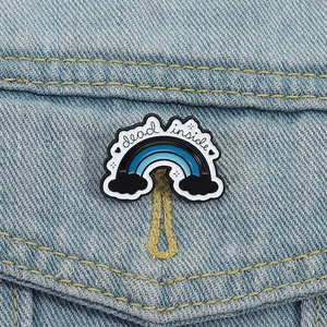 Broche arc-en-ciel bleue avec texte Dead Inside sur une boutonnière de veste denim