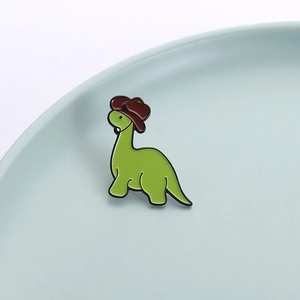 Insigne mignon en émail de dinosaure vert avec un chapeau de cow-boy marron