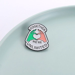 Creative enamel lapel pin with heart hands and 'Together We're Unlimited' slogan