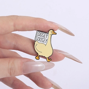 Gros plan sur le pin's en émail canard Loosey Goosey avec détails jaunes et métal