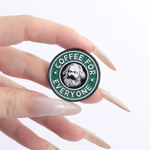 Detail of Karl Marx enamel pin with Coffee for Everyone text held by hand