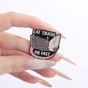 Détail du pin's émaillé opossum avec texte Eat Trash Die Fast et finitions métalliques