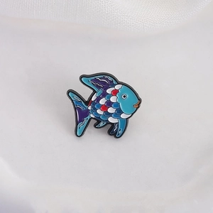 Cute tropical fish enamel brooch with vibrant blue and purple patterns on a white mesh background