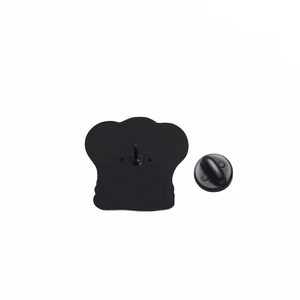 Detail view of the metal chef hat pin back with a black rubber clutch closure