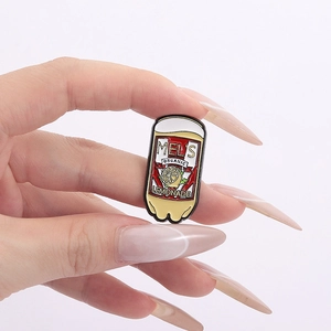 Detailed close-up of a lemonade can enamel pin held by a hand over a white background
