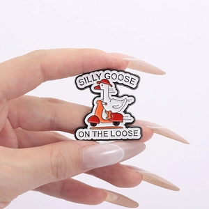 Detail of silly goose on the loose enamel pin featuring a white goose on a scooter