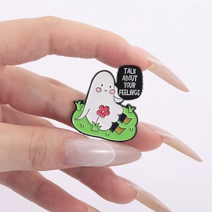 Detail of ghost enamel pin with Talk About Your Feelings text and a small flower