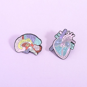 Creative anatomy enamel pins set featuring pastel brain and heart shapes with medical labels