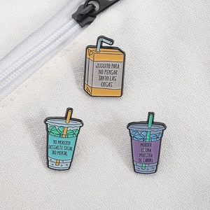 Trois pin's en émail colorés avec texte espagnol sur sac en toile blanche à zip