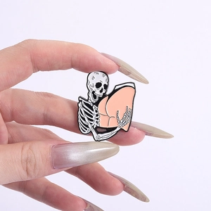 Close-up of a creative skull enamel pin featuring a black and white skeleton design