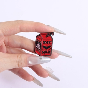 Detail of red enamel Bat Milk pin showing vampire missing poster and carton shape