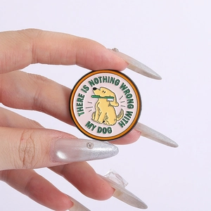 Détail du pin's rond en émail montrant un chien avec brosse à dents et texte sur blanc