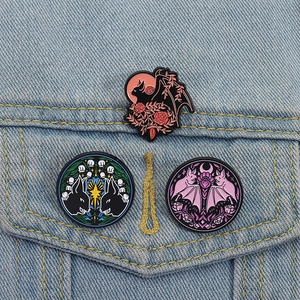 Set di tre spille smaltate in stile gotico con pipistrelli e fiori su giacca denim