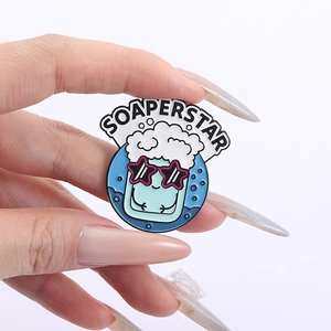 Detail of Soaperstar enamel pin showing a cool blue cup with sunglasses and white foam bubbles